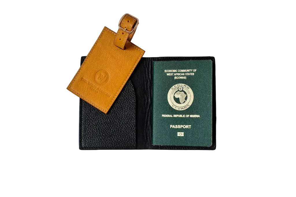 Green passport inside a black leather wallet with a yellow luggage tag on a white background