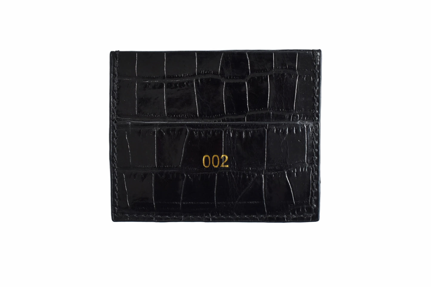 Black crocodile skin cardholder with gold numbering on a white background
