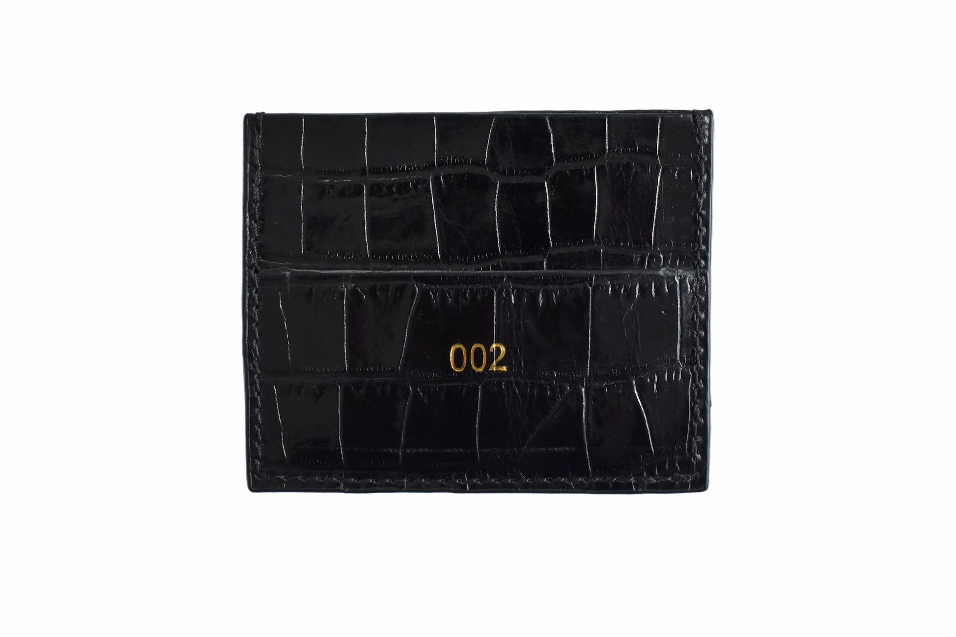 Black crocodile skin cardholder with gold numbering on a white background