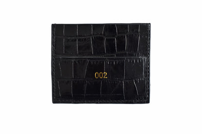 Black crocodile skin cardholder with gold numbering on a white background