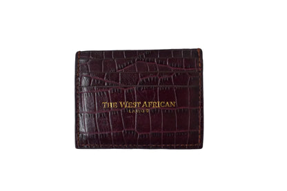 Burgundy leather cardholder with 'The West African' branding on a white background